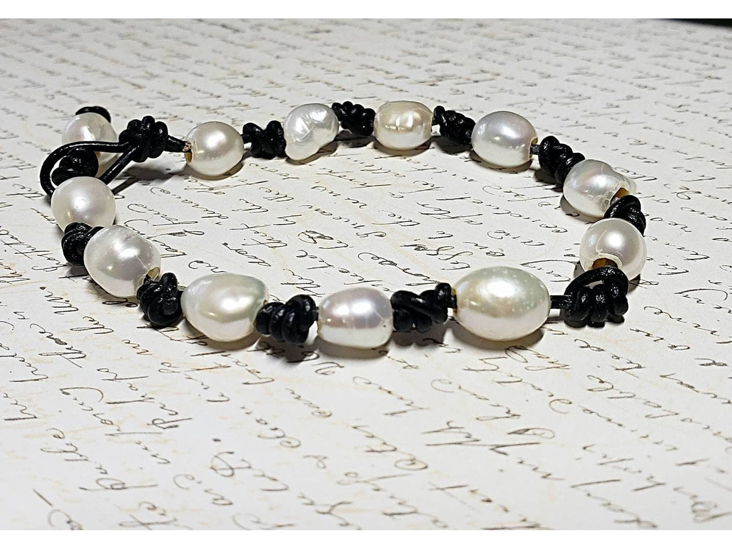 White Pearls knotted on Black leather bracelet.